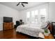 A bedroom with neutral gray bedding, wood floors, and three bright windows at 104 Antilles Cir, Charleston, SC 29492