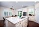 A kitchen island features stone countertops, bar seating, and stainless steel sink at 104 Antilles Cir, Charleston, SC 29492