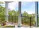 Covered balcony with black iron railings overlooking stunning views of lush greenery and water at 108 Fairbanks Oak Aly # 401, Charleston, SC 29492