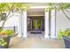 Elegant entrance with white columns, a stone patio, and decorative potted plants at 108 Fairbanks Oak Aly # 401, Charleston, SC 29492