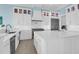 Contemporary kitchen featuring white cabinets, an island with white countertop, stainless steel appliances, and designer lighting at 108 Fairbanks Oak Aly # 401, Charleston, SC 29492