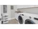 Well-organized laundry room features side-by-side washer and dryer with sink and overhead cabinets at 108 Fairbanks Oak Aly # 401, Charleston, SC 29492