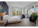 Bright main bedroom with hardwood floors, water view, seating area, and access to a private balcony at 108 Fairbanks Oak Aly # 401, Charleston, SC 29492