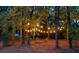 Inviting backyard fire pit area with string lights and Adirondack chairs nestled among mature trees at 111 Coltsgate Ct, Summerville, SC 29485