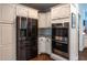 Modern kitchen with stainless steel refrigerator and double ovens, complemented by white cabinetry at 111 Coltsgate Ct, Summerville, SC 29485