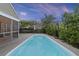 Backyard pool surrounded by lush greenery, with a view of the screened in porch and yard at 1110 Flyway Rd, Summerville, SC 29483