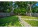 Private backyard features a stone path leading to a fire pit, and tall mature trees at 115 Sully St, Goose Creek, SC 29445