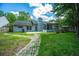 Well-maintained backyard with a stone path, lush lawn, mature trees, and a screened-in porch at 115 Sully St, Goose Creek, SC 29445