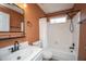 Bathroom with a shower-tub combo, a toilet, and a sink with an orange painted wall at 115 Sully St, Goose Creek, SC 29445