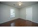 Bedroom featuring hardwood floors, neutral walls, a ceiling fan, a window, and a white door at 115 Sully St, Goose Creek, SC 29445