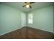 Bedroom with green walls, wood-look flooring, ceiling fan, window, and a white door at 115 Sully St, Goose Creek, SC 29445