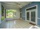Bright sunroom with tiled floor, blue walls, white doors, and a ceiling fan overlooking the backyard at 115 Sully St, Goose Creek, SC 29445
