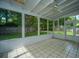 Bright sunroom with tiled floor, white walls, and a ceiling fan overlooking the backyard at 115 Sully St, Goose Creek, SC 29445