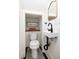 Compact powder room with a modern floating sink, decorative mirror, and stylish black and white tile flooring at 1153 King St, Charleston, SC 29403