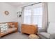 Charming Bedroom with a wooden crib, dresser, and comfortable seating area near the window at 1153 King St, Charleston, SC 29403
