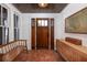 Elegant foyer with terracotta tile flooring, wooden accents, and a classic wooden front door at 1153 King St, Charleston, SC 29403