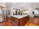 Open-concept kitchen with an island, hardwood floors, stainless steel appliances, and plenty of natural light at 1153 King St, Charleston, SC 29403