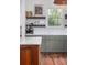 Bright kitchen design featuring open shelving, stainless appliances, green cabinets and a marble countertop at 1153 King St, Charleston, SC 29403
