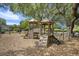 Community playground featuring wooden structures, climbing walls, and swings under the shade of mature trees at 1250 Wide Water Ct, Charleston, SC 29412