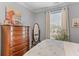 Well-lit bedroom with a tall dresser, decorative mirror and a window with natural light at 130 River Landing Dr # 3202, Charleston, SC 29492