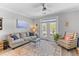 Bright living room featuring a comfortable couch, patterned chair, and balcony access at 130 River Landing Dr # 3202, Charleston, SC 29492