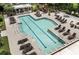 Aerial view of a large in-ground pool with many lounge chairs, tables, and a pergola for outdoor relaxation at 130 River Landing Dr # 3202, Charleston, SC 29492