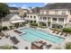 Community pool with lounge chairs surrounded by multi-Gathering homes with balconies and manicured landscaping at 130 River Landing Dr # 3202, Charleston, SC 29492