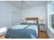 Bright bedroom with a cozy woven headboard, side tables, and hardwood floors bathed in natural light at 130 River Landing Dr # 7106, Charleston, SC 29492