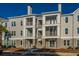 Multi-level condo building showcasing large balconies, a palm tree, and reserved parking spaces at 130 River Landing Dr # 7106, Charleston, SC 29492