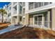 Exterior view of condo building features private patios with white railings and manicured grounds at 130 River Landing Dr # 7106, Charleston, SC 29492