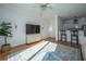Open-concept living room with hardwood floors, white walls, ceiling fan, and adjacent kitchen at 130 River Landing Dr # 7106, Charleston, SC 29492