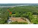 Aerial view of private home on expansive acreage with a pond and wooded landscape at 1375 Tannanger Trl, Awendaw, SC 29429