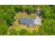 Aerial view highlighting a home nestled among trees, with a spacious backyard and a graveled parking area at 1375 Tannanger Trl, Awendaw, SC 29429