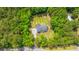 Aerial view of a house with a well-kept yard and a firepit surrounded by trees at 1375 Tannanger Trl, Awendaw, SC 29429