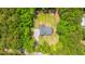 Aerial view of a single-Gathering home boasting a landscaped backyard with a firepit, surrounded by mature trees and lush greenery at 1375 Tannanger Trl, Awendaw, SC 29429