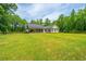 Exterior view of house and fenced-in backyard, featuring a well-maintained lawn and wooded backdrop at 1375 Tannanger Trl, Awendaw, SC 29429