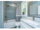 A relaxing bathroom with blue accent wall tile, shower-tub combo, and natural light at 1375 Tannanger Trl, Awendaw, SC 29429