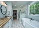 Bright bathroom featuring a freestanding tub, glass enclosed shower, patterned tile floor, and wood countertop at 1375 Tannanger Trl, Awendaw, SC 29429