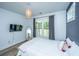 Serene bedroom with natural light, neutral tones, TV, and a mirror creating a cozy and inviting space at 1375 Tannanger Trl, Awendaw, SC 29429