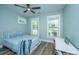Comfortable bedroom features two windows, light blue walls, ceiling fan, and a bed with decorative pillows at 1375 Tannanger Trl, Awendaw, SC 29429