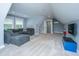 Spacious bonus room with gray sectional sofa, plush carpeting, and natural light from multiple windows at 1375 Tannanger Trl, Awendaw, SC 29429
