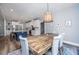 Dining room with wooden table and chairs, wood floors, light fixture and an open view to the kitchen at 1375 Tannanger Trl, Awendaw, SC 29429