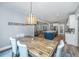 Dining room with decorative sign, wooden table with blue chairs, wood floors and an open view to the kitchen at 1375 Tannanger Trl, Awendaw, SC 29429