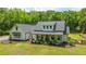 Charming white farmhouse-style home with a welcoming front porch and lush green lawn at 1375 Tannanger Trl, Awendaw, SC 29429