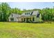 Beautiful modern farmhouse with a welcoming porch, surrounded by a sprawling green yard at 1375 Tannanger Trl, Awendaw, SC 29429