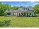 Beautiful white farmhouse with a large front yard and inviting porch perfect for relaxing at 1375 Tannanger Trl, Awendaw, SC 29429