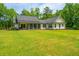 Backyard view of home's screened in porch and abundant green grass at 1375 Tannanger Trl, Awendaw, SC 29429