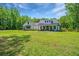Charming white farmhouse with a covered front porch and lush green lawn at 1375 Tannanger Trl, Awendaw, SC 29429