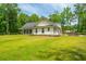 Charming white farmhouse with a covered porch and ample green space at 1375 Tannanger Trl, Awendaw, SC 29429