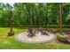 Cozy outdoor fire pit with seating, perfect for gatherings surrounded by lush green trees and landscaping at 1375 Tannanger Trl, Awendaw, SC 29429